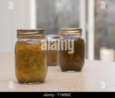 Homemade pickled relish bottles on kitchen counter top. Stock Photo