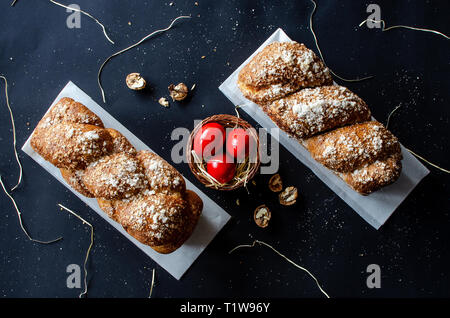 Easter Breads with decorated red painted eggs and wallnuts on dark background Stock Photo