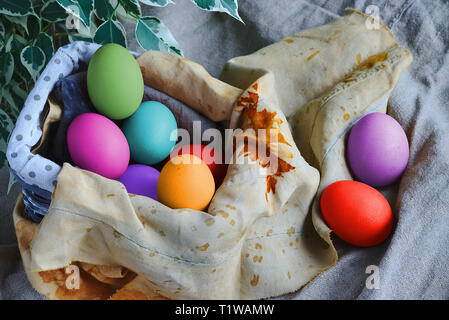 multicolored Easter eggs in a basket and printed cloths Stock Photo