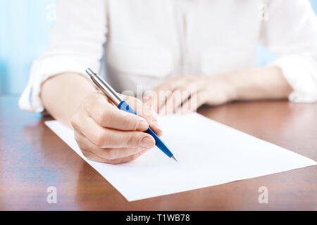 Hand of businesswoman writing on paper in office Stock Photo