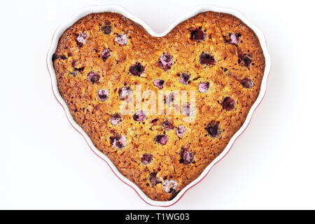 Oatmeal pie with cherry in the ceramic form in the shape of a heart on a white background Stock Photo