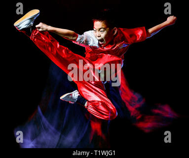 wushu chinese boxing kung fu Hung Gar fighter isolated child isolated on black background with speed light painting effect motion blur Stock Photo