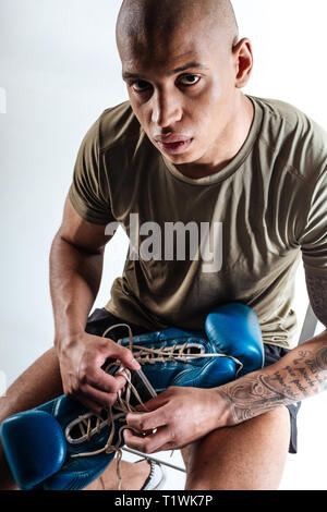 Man holding blue boxing gloves befvore training Stock Photo