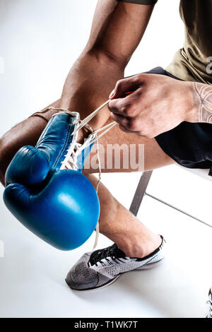 Man lacing boxing gloves before starting training Stock Photo