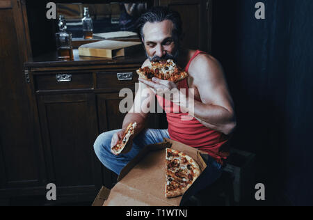 Handsome hungry man is eating pizza. Stock Photo