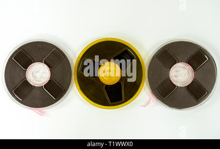 three audio tapes on a reel of different colors, on a white background. Stock Photo