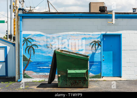 Garbage skip positioned in front of tropical mural in downtown Joliet Stock Photo