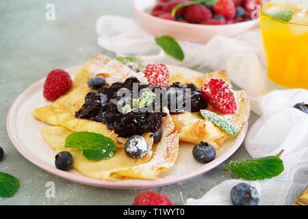 French crepes with fresh fruits and  blueberry compote topping, selective focus Stock Photo