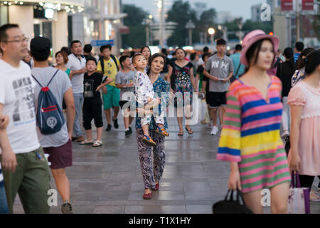 Beijing, China - 08 02 2016: Asian homeless woman with her child in a street of Beijing, China Stock Photo