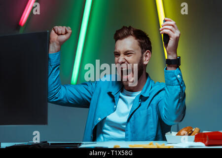 handsome and happy man holding computer mouse and showing yes gesture Stock Photo