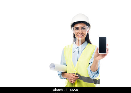 Smiling engineer with blueprint showing smartphone with blank screen isolated on white Stock Photo