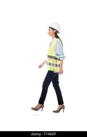 Side view of engineer in safety vest and high-heeled shoes walking isolated on white Stock Photo