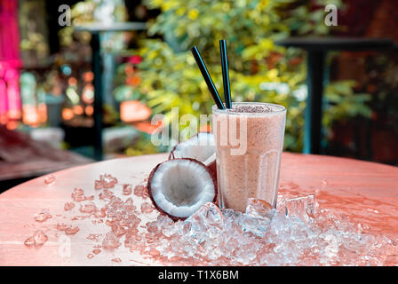 Homemade chocolate shake with coconut and chia seeds served on a wood table with ice. Stock Photo