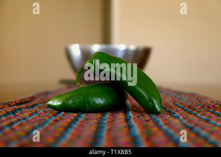Two jalapeño peppers (capsicum annuum) on a colorfully patterned fabric; a pair of jalapeno chiles. Stock Photo