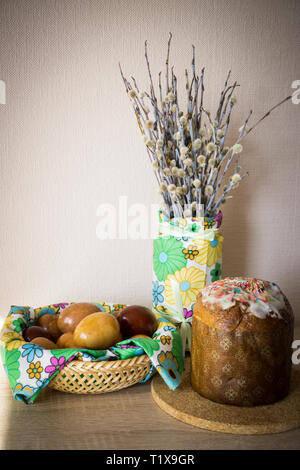 Table before Easter decorated with Easter cake, willow and eggs painted with onion peel Stock Photo