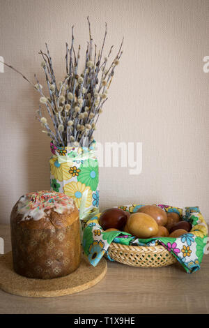 Table before Easter decorated with Easter cake, willow and eggs painted with onion peel Stock Photo