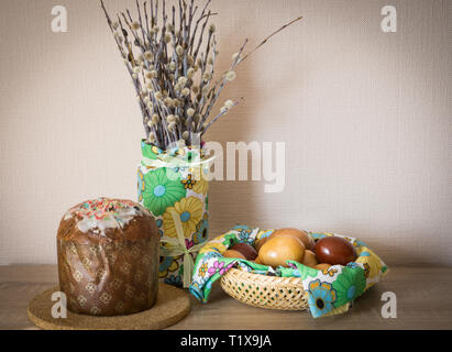 Table before Easter decorated with Easter cake, willow and eggs painted with onion peel Stock Photo