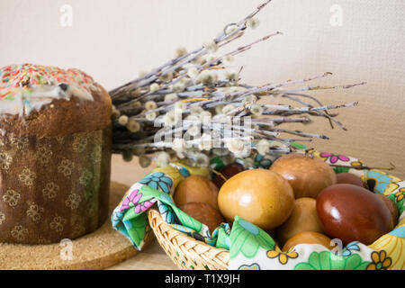 Table before Easter decorated with Easter cake, willow and eggs painted with onion peel Stock Photo