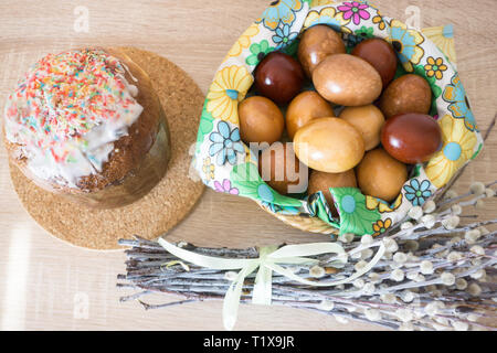 Table before Easter decorated with Easter cake, willow and eggs painted with onion peel Stock Photo