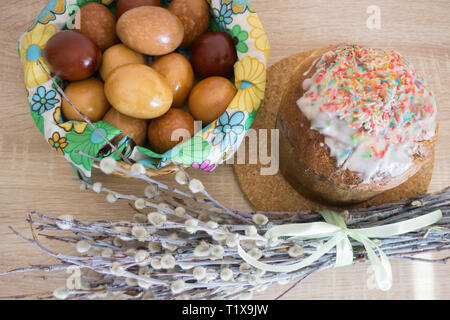 Table before Easter decorated with Easter cake, willow and eggs painted with onion peel Stock Photo