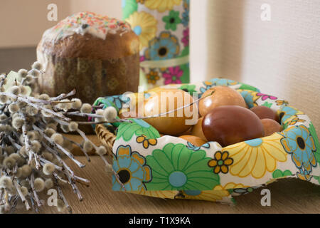 Table before Easter decorated with Easter cake, willow and eggs painted with onion peel Stock Photo