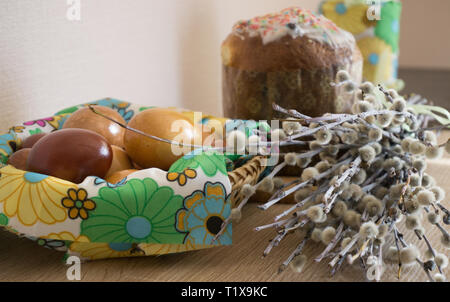 Table before Easter decorated with Easter cake, willow and eggs painted with onion peel Stock Photo