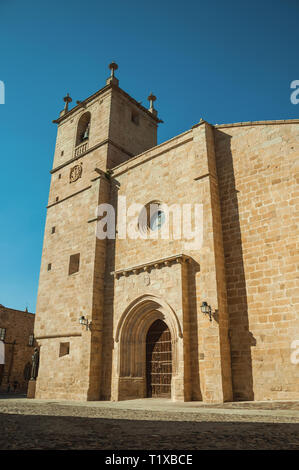 The gothic Santa Maria Cathedral with big wooden door in front of square at Caceres. A charming town with a fully preserved old city center in Spain. Stock Photo