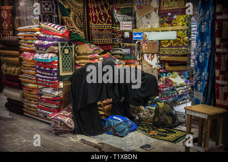 Two women covered in black praying in the historic district of Al Balad Jeddah, Saudi Arabia Stock Photo