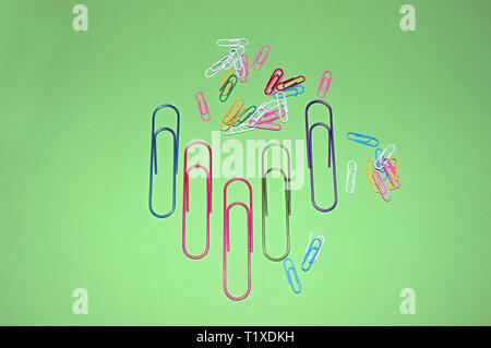 Paper clips on the table as background.Bunch of color paperclips on a green background Stock Photo