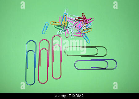 Paper clips on the table as background.Bunch of color paperclips on a green background Stock Photo