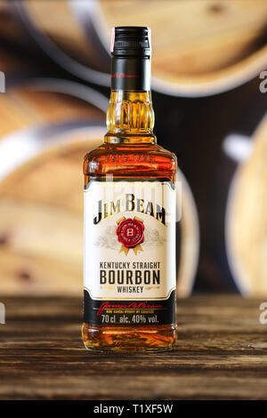 March 28, 2019, Minsk, Belarus - Bottle of kentucky straight bourbon whiskey on wooden table with barrel on background Stock Photo
