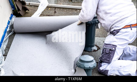 Construction worker using tarpaulin as covering sheet to protect the ground. Stock Photo