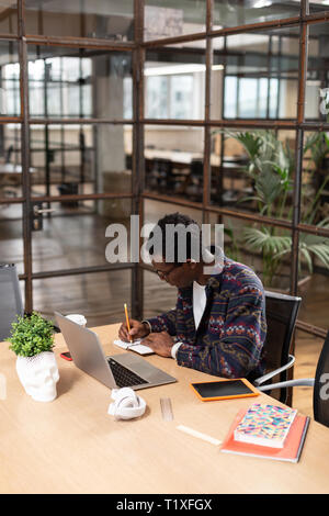 Man taking important notes while working in office Stock Photo