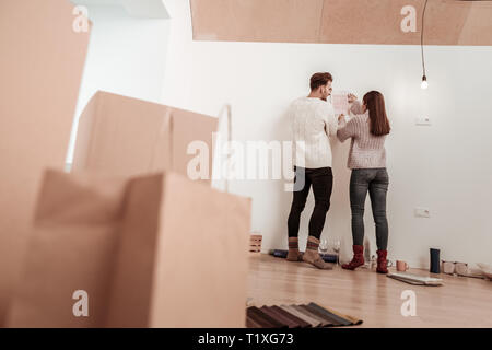 Couple wearing jeans and socks standing in room with no furniture Stock Photo