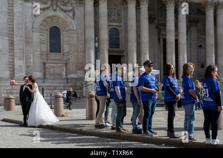 A Chinese wedding couple stand outside St. Paul's Cathedral alongside some Asian corporate achievers, on 25th March 2019, in London, England.