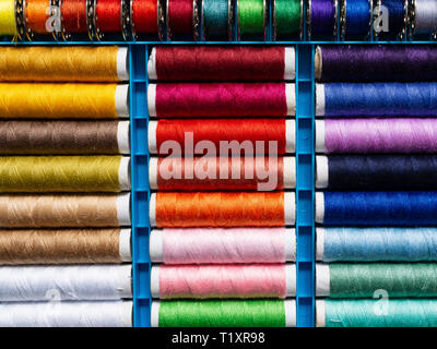 Box of multicolored bobbins of sewing thread. Top view. Open composition. Colorful, vibrant background. Stock Photo