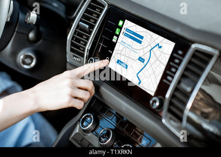 Touching a monitor with navigation map of the modern car, close-up view Stock Photo