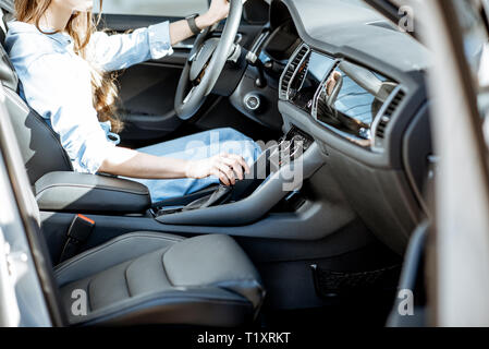 Woman switching gear, holding handle of the automatic gearbox of the modern car Stock Photo