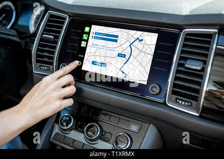 Touching a monitor with navigation map of the modern car, close-up view Stock Photo