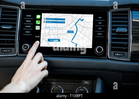 Touching a monitor with navigation map of the modern car, close-up view Stock Photo