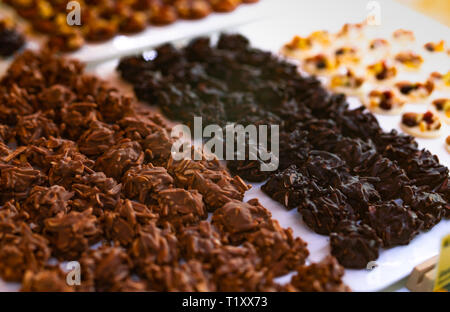 Almond coated dark chocolate and milk chocolate on white plate. Healthy dark chocolate almond bite. High protein and carbohydrate food. High energy Stock Photo