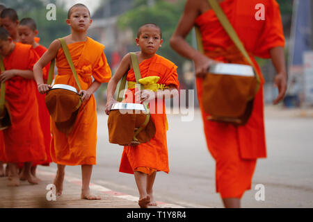 Luang Prabang, Laos. 29th Mar, 2019. Monks walk in the street after Tak Bat (Alms giving) in Luang Prabang, Laos, March 29, 2019. Tak Bat is a tradition in Laos Buddhist culture. Credit: Wang Jingqiang/Xinhua/Alamy Live News Stock Photo