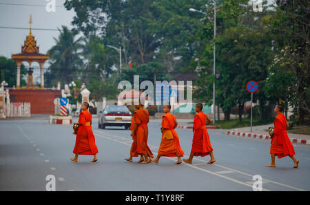 Luang Prabang, Laos. 29th Mar, 2019. Monks walk in the street after Tak Bat (Alms giving) in Luang Prabang, Laos, March 29, 2019. Tak Bat is a tradition in Laos Buddhist culture. Credit: Wang Jingqiang/Xinhua/Alamy Live News Stock Photo