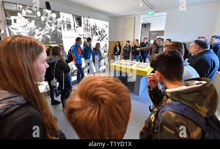 Geisa, Germany. 29th Mar, 2019. Students from Hünfeld, Schmalkalden and Weimar will be guided by contemporary witnesses through the exhibitions on the grounds of the former U.S. camp of the Point Alpha Memorial and along the border reconstructions. Cadets from the U.S. Department of Defense Education Activity (DODEA) High School in Wiesbaden are conducting the traditional flag ceremony, the so-called 'Retreat Ceremony', on the occasion of the 29th anniversary of the last US border patrol at Point Alpha. Credit: Martin Schutt/dpa-Zentralbild/dpa/Alamy Live News Stock Photo