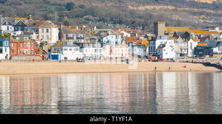 Lyme Regis, Dorset, UK. 29th March 2019. UK Weather: Another day of glorious sunshine and bright blue skies as the seaside resort town of Lyme Regis as the early spring heatwave continues.  The picturesque buildings are reflected in the calm water. Credit: Celia McMahon/Alamy Live News Stock Photo