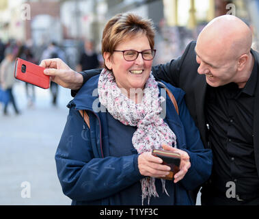 Wiesbaden, Germany. 29th Mar, 2019. Pickpocket and trick thief artist Giovanni Alecci takes off Doris Beuth's mobile phone unnoticed in the Wiesbaden pedestrian zone as part of the police security day. The police in Hesse want to fight street crime and work with the tricks of thieves. Actions and information stands are designed to improve citizens' sense of security. Credit: Arne Dedert/dpa/Alamy Live News Stock Photo