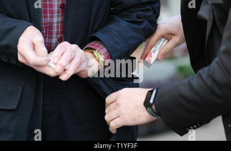 Wiesbaden, Germany. 29th Mar, 2019. Pickpocket and trick thief artist Giovanni Alecci (r) steals the cigarette box from a distracted passer-by in the Wiesbaden pedestrian precinct unnoticed by the police as part of Security Day. The police in Hesse want to fight street crime and work with the tricks of thieves. Actions and information stands are designed to improve citizens' sense of security. Credit: Arne Dedert/dpa/Alamy Live News Stock Photo