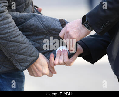 Wiesbaden, Germany. 29th Mar, 2019. Pickpocket and trick thief artist Giovanni Alecci (r) distracts a passer-by in Wiesbaden's pedestrian precinct from the police security day by attaching a security magnet to his jacket. The police in Hesse want to fight street crime and work with the tricks of thieves. Actions and information stands are designed to improve citizens' sense of security. Credit: Arne Dedert/dpa/Alamy Live News Stock Photo
