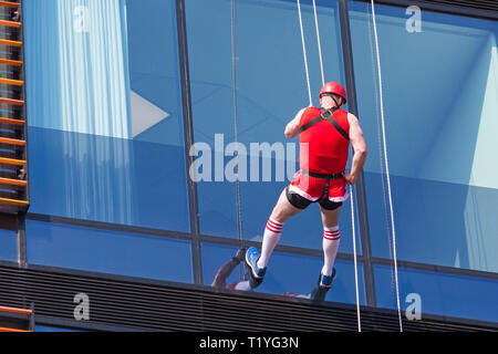 Bournemouth, Dorset, UK. 29th Mar, 2019. Staff working for telecommunications provider 4Com abseil down their new office building at One Lansdowne Plaza in Bournemouth which is 100ft high. They are raising funds for Hope Housing and Hope AOK Rucksack Appeal who provide support to homeless in Bournemouth. A lovely warm sunny day for the descent! Man abseils down. Credit: Carolyn Jenkins/Alamy Live News Stock Photo