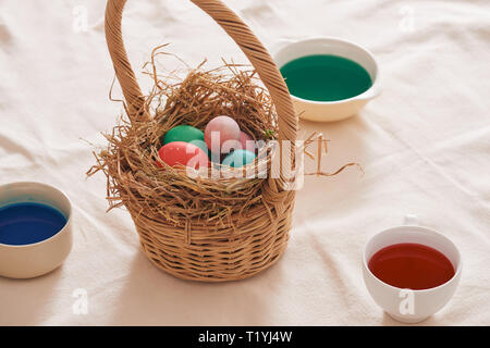 Beautiful Easter composition with multicolored eggs and flowers on linen background Stock Photo
